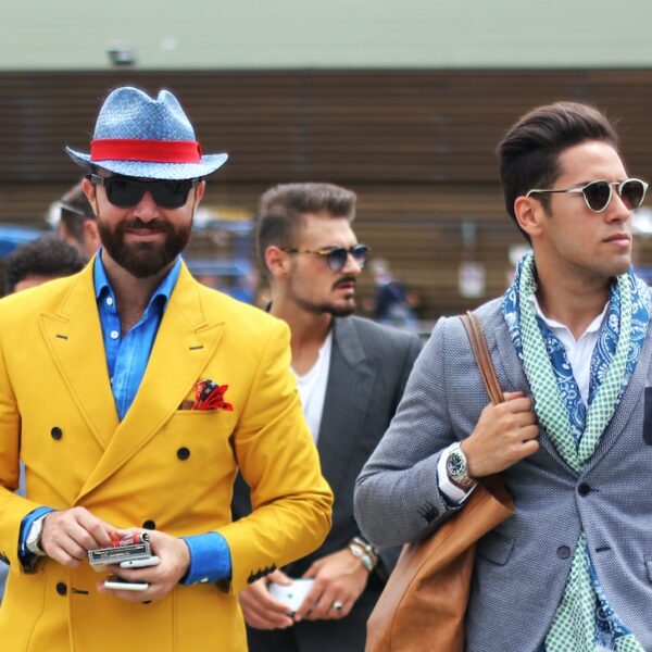 two man wearing yellow and grey suit jacket standing close together