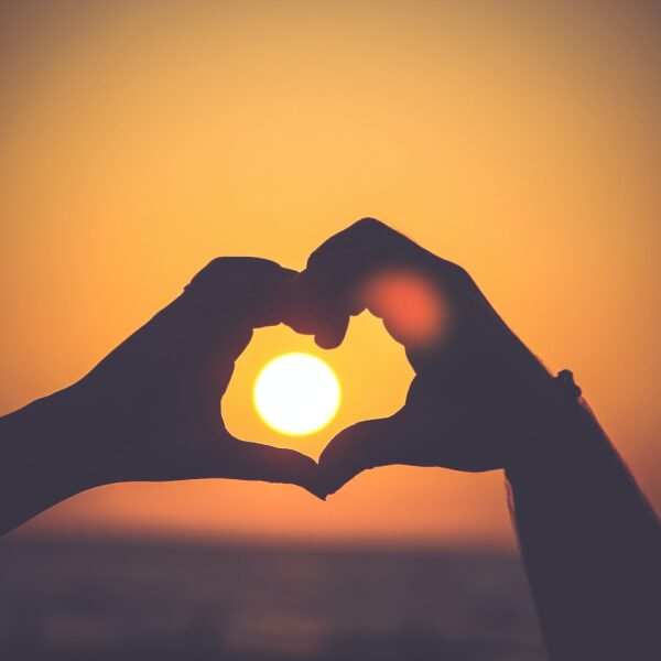 silhouette of person's hands forming heart