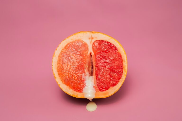 Sexy grapefruit with sperm against pink background