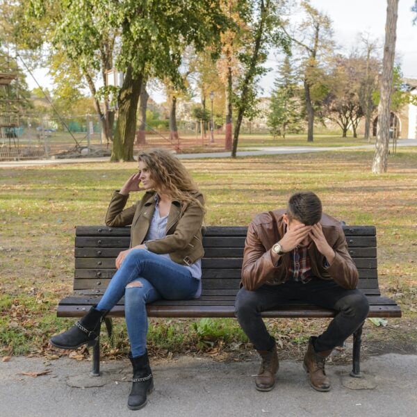 Woman And Man Sitting on Brown Wooden Bench