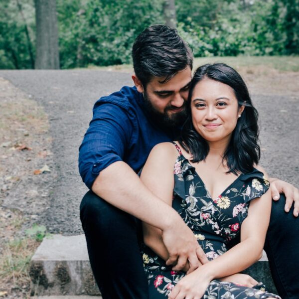 man wearing blue dress shirt and black pants and woman in black floral dress