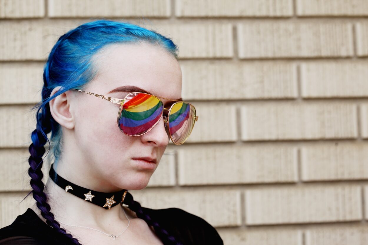 a woman with blue hair and rainbow glasses