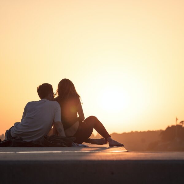 couple sitting near trees during golden hour